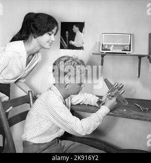 Hobby negli anni '1950s. Un ragazzo è seduto ad un tavolo con un modello di plastica di un aereo bomba americano B-26. È realizzato come un kit di plastica e assemblato dalle parti ad un aereo finito. Poi fu dipinta e decorata. In questo periodo, la costruzione di modelli di aerei e automobili era un hobby molto popolare. Svezia 1959 Kristoffersson Ref CH25-12 Foto Stock