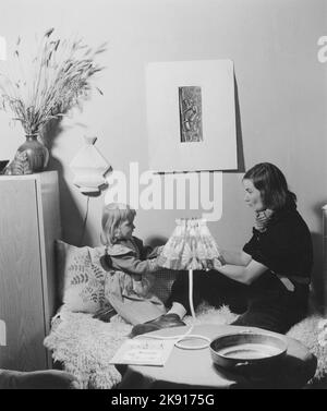 Donna negli anni '1950s. Una giovane donna dai capelli scuri a casa con sua figlia. Svezia 1950 Foto Stock