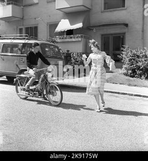 Adolescenti degli anni '1950s. Un ragazzo adolescente sta guidando il suo ciclomotore e una donna sembra che lei esce di fronte a lui per strada senza guardare. Svezia 1958 Ref CV79 Foto Stock