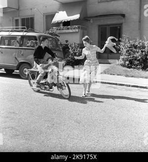 Adolescenti degli anni '1950s. Un ragazzo adolescente sta guidando il suo ciclomotore e una donna sembra che lei esce di fronte a lui per strada senza guardare con attenzione. Svezia 1958 Ref CV79 Foto Stock