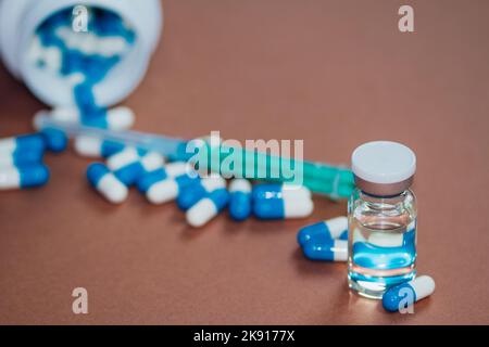 Un primo piano di droghe iniettabili e capsule dopanti illegali su un tavolo - truffare la droga negli sport Foto Stock