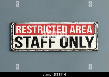 Semplice piastra metallica che dice il personale dell'area limitata appeso solo alla parete grigia in una sala meccanica Foto Stock
