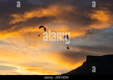 Un paio di parapendio a motore che volano al tramonto vicino a Hanksville, Utah. Foto Stock