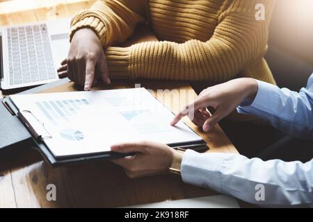 Un consulente di affari femminile descrive un programma di vendita per regolare le strategie di affari per i proprietari di affari delle donne. Foto Stock