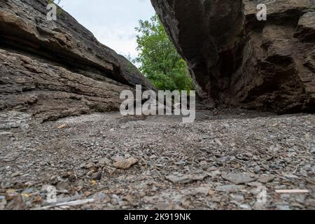 Un piccolo sentiero sabbioso con grandi rocce Foto Stock