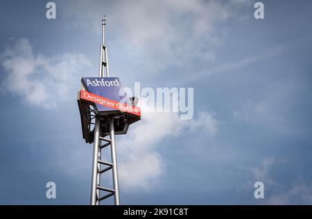 Alto cartello d'ingresso dell'Ashford Outlet Centre, outlet di abbigliamento firmato nel Kent, Inghilterra. Foto Stock