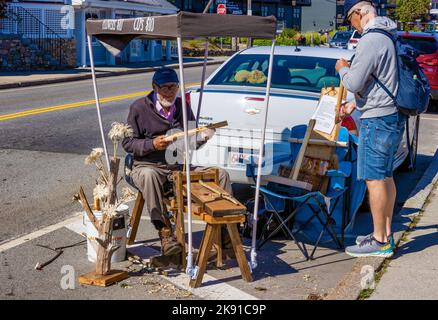 Plymouth, Massachusetts, Stati Uniti d'America - 12 settembre 2022: Un vender di strada imposta il negozio dietro un'automobile parcheggiata che vende i suoi articoli di legno intagliati a mano. Foto Stock