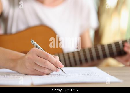 Mano femmina che scrive note di nuova canzone Foto Stock