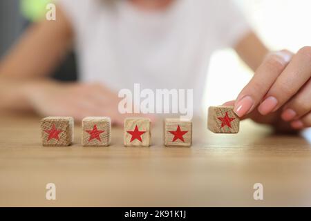 Mano femmina che tiene cubo di legno con stella rossa Foto Stock