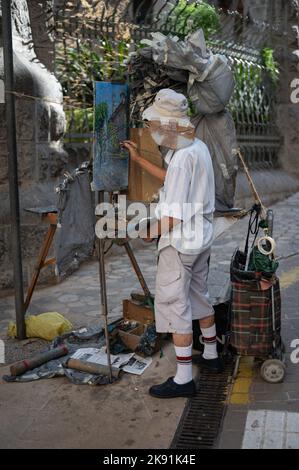 Uno scatto verticale di un gentleman asiatico anziano che dipinge un quadro sulla strada Foto Stock