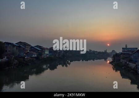 Srinagar, India. 25th Ott 2022. Un'eclissi solare parziale è visto sopra il fiume Jehlum in Srinagar. L'eclissi solare parziale è stato visto in tutto il mondo oggi. L'eclisse segna la seconda e ultima eclisse solare del 2022. La prossima eclissi solare sarà visibile dall'India il 2 agosto 2027. (Foto di Saqib Majeed/SOPA Images/Sipa USA) Credit: Sipa USA/Alamy Live News Foto Stock