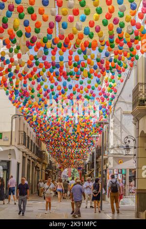 La gente che cammina lungo la Calle de la bola alla Feria de ronda con lanterne colorate, 08-31-2022 Ronda, Malaga, Andalucia, Spagna Foto Stock