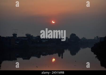 Srinagar, India. 25th Ott 2022. Un'eclissi solare parziale si vede sopra il fiume Jehlum a Srinaga. L'eclissi solare parziale è stato visto in tutto il mondo oggi. L'eclisse segna la seconda e ultima eclisse solare del 2022. La prossima eclissi solare sarà visibile dall'India il 2 agosto 2027. (Foto di Saqib Majeed/SOPA Images/Sipa USA) Credit: Sipa USA/Alamy Live News Foto Stock