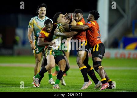 Kayal Iro di Cook Islands è affrontato da Nixon Putt di Papau Nuova Guinea e Kevan APPO di Papau Nuova Guinea durante la partita di Coppa del mondo di Rugby League D al Halliwell Jones Stadium di Warrington. Data immagine: Martedì 25 ottobre 2022. Foto Stock