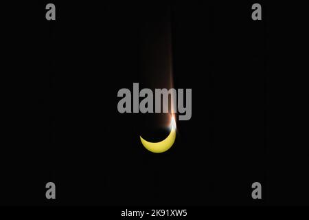 Eclissi solare parziale su sfondo nero. L'ombra della Luna copriva parte del sole. Raro fenomeno astronomico. Osservazione spaziale, ricerca scientifica. Foto Stock