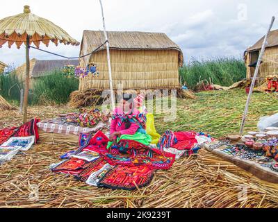 PUNO, PERÙ, 20 GENNAIO 2015: Isole Uros sul lago Titicaca - le donne locali in abbigliamento tradizionale vendono artigianato ai turisti in Puno, Perù. Foto Stock