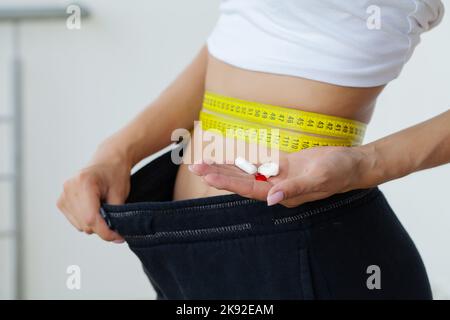 La donna che mostra quanto peso ha perso. Foto Stock