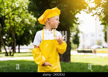 Bel cuoco bambino in giallo chef cappello e grembiule giallo