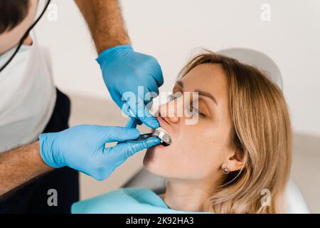 Il medico inserisce il vassoio per impronte e facendo il getto di denti al paziente in odontoiatria prima dell'impianto dentale. Procedura di creazione di protesi dentarie, c Foto Stock