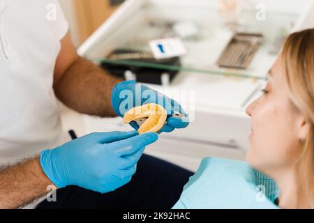 Il medico inserisce il vassoio per impronte e facendo il getto di denti al paziente in odontoiatria prima dell'impianto dentale. Procedura di creazione di protesi dentarie, c Foto Stock