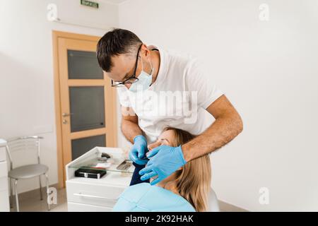 Procedura di creazione di protesi dentarie, corone e allineatori. Il medico inserisce il vassoio per impronte e facendo il getto di denti al paziente in odontoiatria prima d Foto Stock