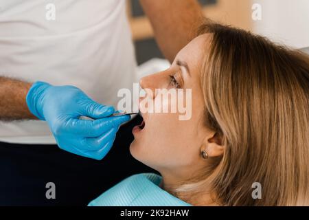 Il medico inserisce il vassoio per impronte e facendo il getto di denti al paziente in odontoiatria prima dell'impianto dentale. Procedura di creazione di protesi dentarie, c Foto Stock