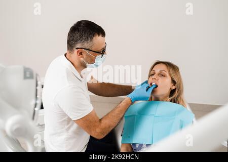 Il medico inserisce il vassoio per impronte e facendo il getto di denti al paziente in odontoiatria prima dell'impianto dentale. Procedura di creazione di protesi dentarie, c Foto Stock