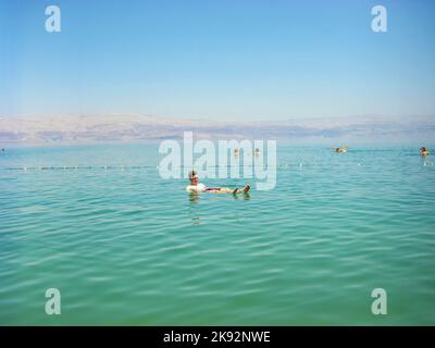 Mar Morto, Israele - 31 marzo 2008: Le persone che galleggiano sull'acqua nel Mar Morto Israel.The Mar Morto è il secondo corpo d'acqua più saliente del mondo, con un Foto Stock