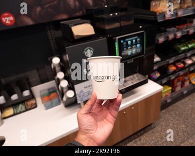 Una tazza di caffè accanto a una macchina automatica Starbucks presso il negozio Amazon Go di New York. Foto di Francis Specker Foto Stock