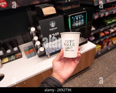 Una tazza di caffè accanto a una macchina automatica Starbucks presso il negozio Amazon Go di New York. Foto di Francis Specker Foto Stock