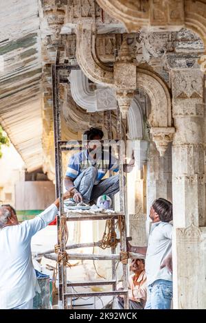 UDAIPUR, INDIA - Oct 21, 2012: Operaio riparare la facciata del palazzo della città a Udaipur, India. La fondazione del forte fu posta nel 1559 da Udai Sin Foto Stock