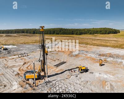 Carro di perforazione per la costruzione di una nuova miniera su un campo in cumulo Foto Stock