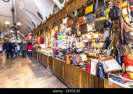 CRACOVIA, POLONIA - 4 MAGGIO: Persone in transito con bancarelle di souvenir artigianali della sala di stoffa gotica Sukiennice sulla piazza del mercato principale il 5 maggio, Foto Stock