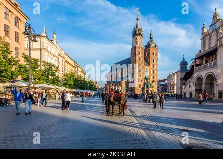 CRACOVIA, POLONIA - Oct 7, 2014: Carrozze a cavallo di fronte alla chiesa di Mariacki sulla piazza principale della città di Cracovia. Fare un giro a cavallo in una carrozza è molto pop Foto Stock