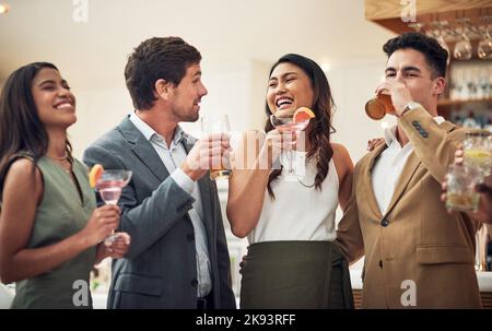 A volte gli amici si incontrano per un drink, un gruppo di giovani amici che si gustano bevande alcoliche in un bar. Foto Stock
