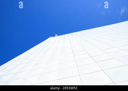 Piastrelle bianche. Vista dall'alto dell'angolo della facciata di un edificio generico di colore bianco sul cielo blu. Foto Stock