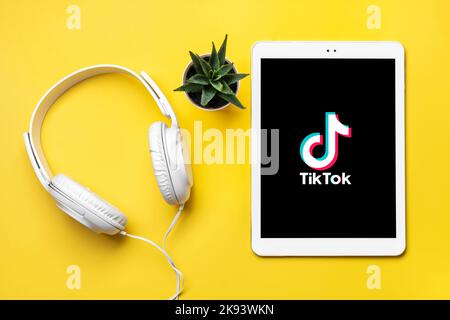 Bangkok, Thailandia. Ottobre 2022 Tablet Tik Tok icona applicazione, logo sullo schermo e cuffie wireless su sfondo colorato rete di social media trendy Foto Stock