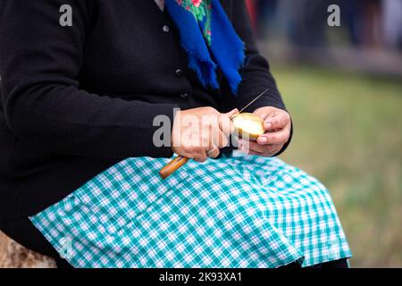 Le mani della donna stanno sbucciando le patate con un coltello. Foto Stock