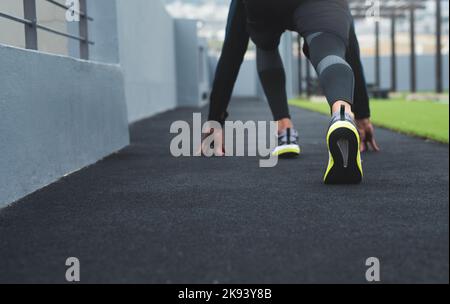 Preparati e preparati a partire. Primo piano di un uomo sportivo in posizione di partenza mentre si pratica all'aperto. Foto Stock