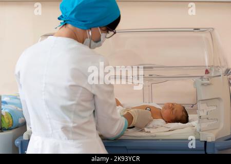 Neonatologia. Medico che ascolta il battito cardiaco di un neonato in un incubatore infantile Foto Stock