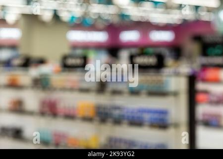 Immagine sfocata un negozio di bellezza con varietà di prestigio e cosmetici di massa, trucco, fragranza, cura della pelle, bagno e corpo, strumenti per la cura dei capelli e salone, unghie Foto Stock