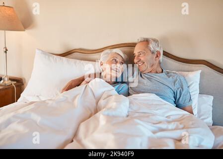 Potrei rimanere coccolato in su in queste braccia per sempre. Una coppia anziana affettuosa sdraiata nel letto e tenente l'un l'altro nella loro casa di cura. Foto Stock