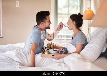 Colazione romantica per due all'interno di una camera da letto. Macchina  per il caffè e caffè bicchieri, croissant, marmellata di lamponi e meringa  fiori su legno vassoio. Romantico Foto stock - Alamy