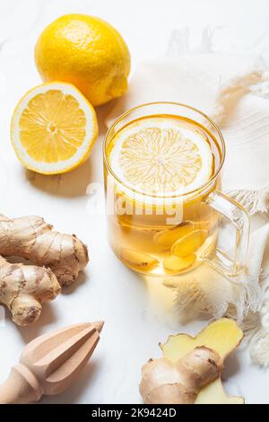 Tè allo zenzero in una tazza di vetro. Inverno vitamina bere per l'immunità di aumento. Foto Stock