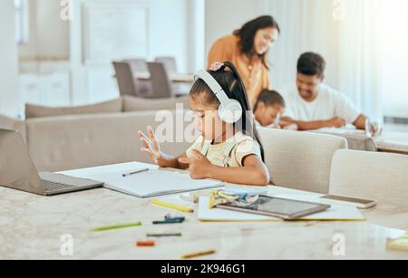 Bambino, mano e conteggio alla scrivania con libro per matematica, lavoro a casa o l'istruzione in famiglia. Ragazza, computer portatile e dita con cuffie, computer o. Foto Stock