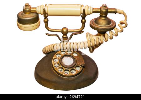 Un vecchio e usato avorio d'epoca e telefono di casa di colore dorato, un oggetto da collezione per ricordare la comunicazione dei tempi antichi Foto Stock