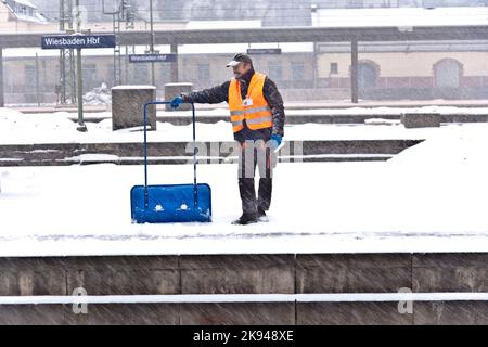 Wiesbaden, Germania - 12 dicembre 2009: Il lavoratore pulisce la piattaforma ferroviaria dalla neve in caso di forte tempesta di neve per prevenire incidenti a Wiesbaden, Germania Foto Stock