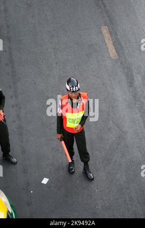 Bangkok, Thailandia - 22 dicembre 2009: Guardia di sicurezza sulla strada principale sta regolando il traffico e i passeggeri alla stazione degli autobus, Sukhumvit Road Foto Stock