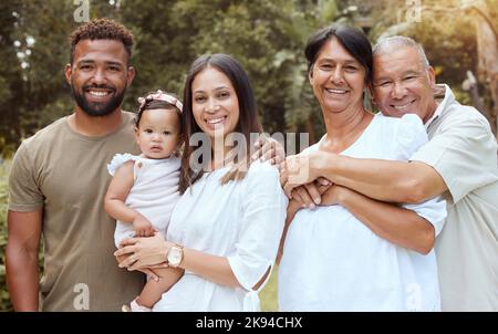 Famiglia nera, felice e abbraccio con la gente che si unisce in natura spendendo tempo di qualità insieme. Ritratto di una mamma, di un bambino e di persone anziane all'aperto Foto Stock