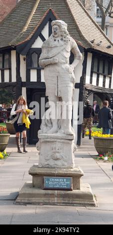 Statua di Carlo II in Soho Square Gardens, Soho, Londra, UK - piccola casa in stile Tudor in mezzo a giardini e persone che camminano intorno ai giardini, sp Foto Stock